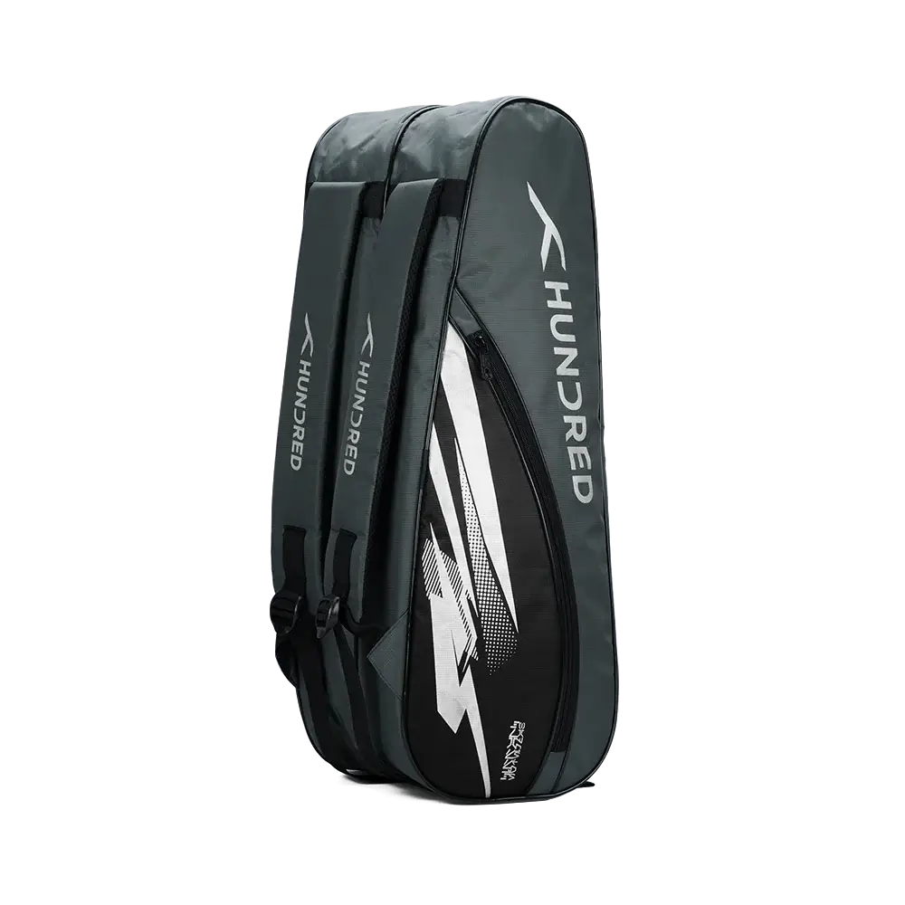 HUNDRED Cosmogear Kit Bag in dark grey with black panels, white graphics, and multiple zippered racket compartments.