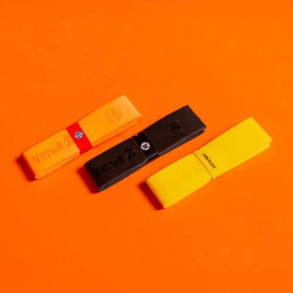 Victor x Dragon Ball Z Grip in polyurethane, shown as three wraps in neon orange, dull black and neon yellow