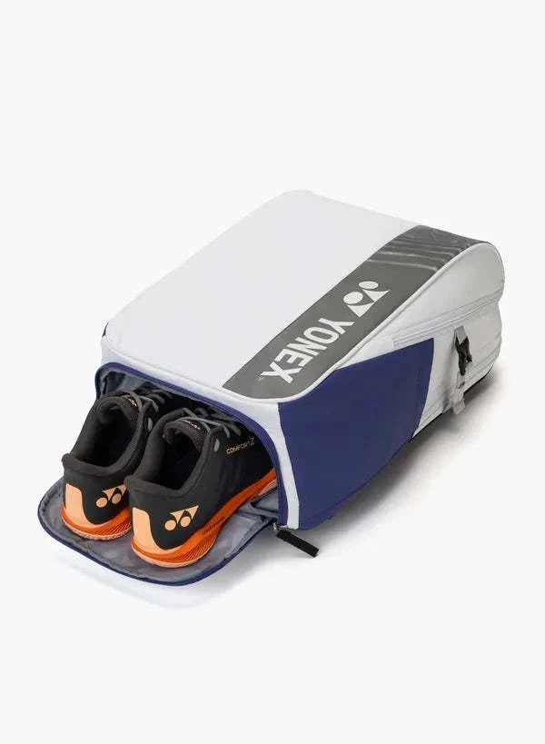 Yonex Club Series badminton bag in white and navy blue, featuring a zippered compartment holding black and orange shoes