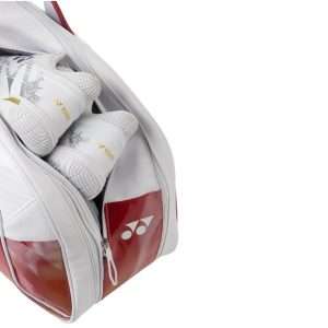 Yonex Expert Series Tournament badminton bag in white with red panels, showing a zippered compartment holding white Yonex shoes