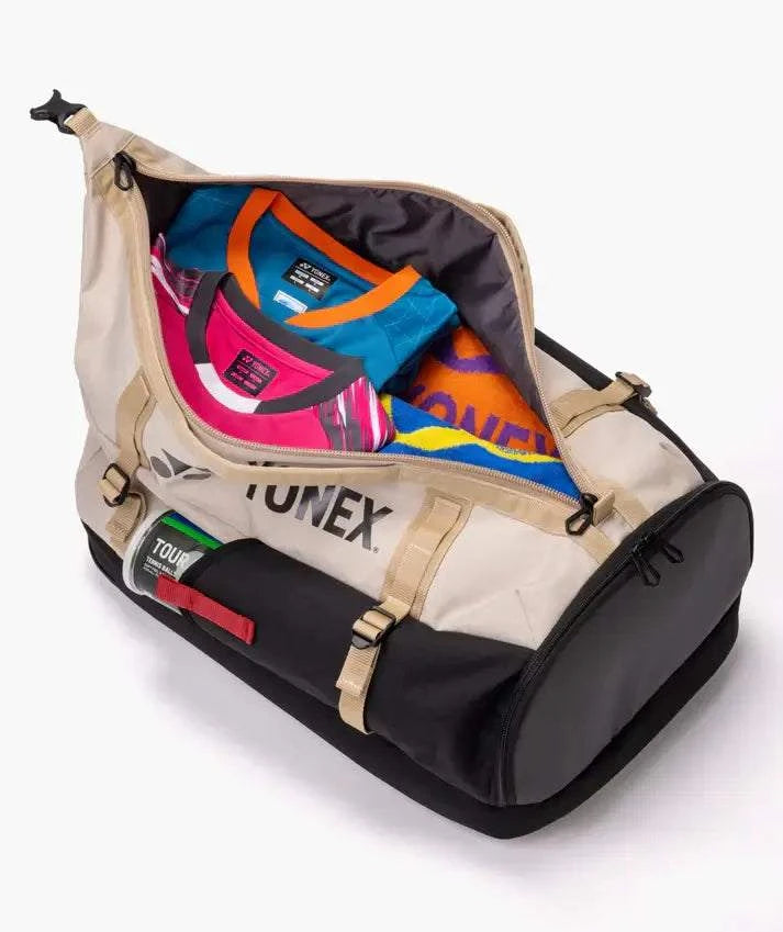 Yonex GEARLOGIC Backpack in beige and black with a wide-open zippered compartment showing colorful sports apparel and gear