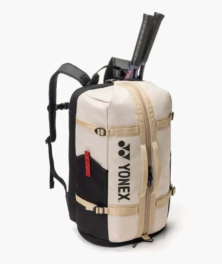Yonex GEARLOGIC Backpack in cream and black with beige straps, front zipper, and a tennis racket carried inside