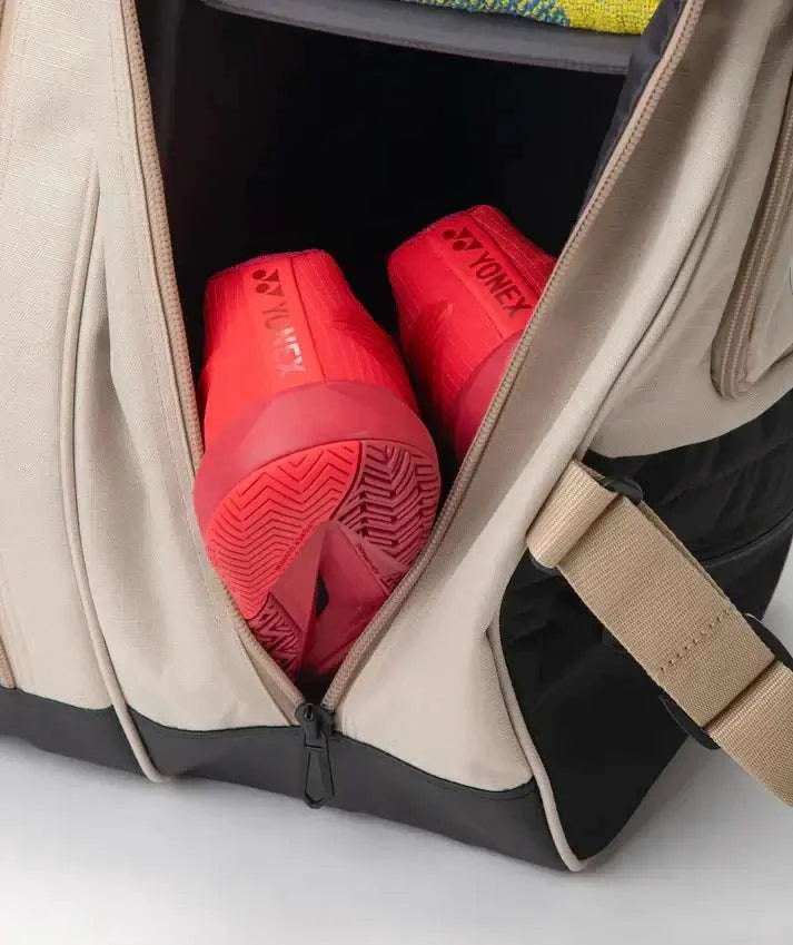 Yonex GEARLOGIC RACQUET BAG in beige and black with an open shoe compartment holding two bright red Yonex shoes