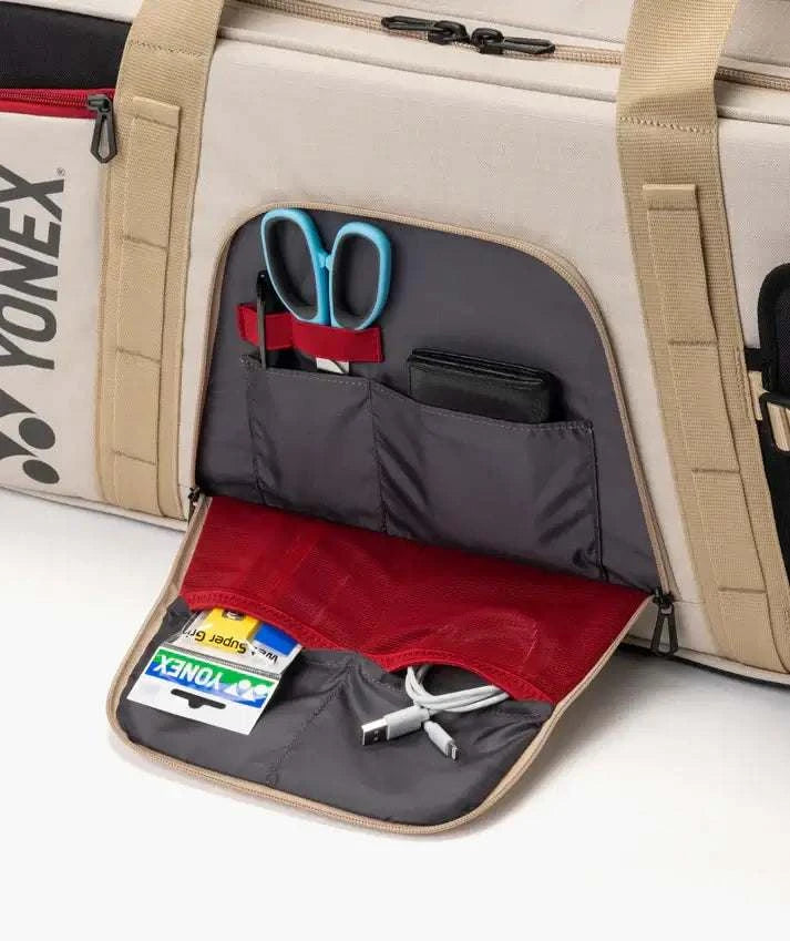 Yonex GEARLOGIC Tournament Bag in beige with dark gray organizer pockets, red lining and blue-handled scissors