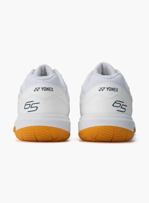 Yonex Power Cushion 65 Z4 Slim badminton shoes in white synthetic leather with orange rubber soles and 65 heel branding