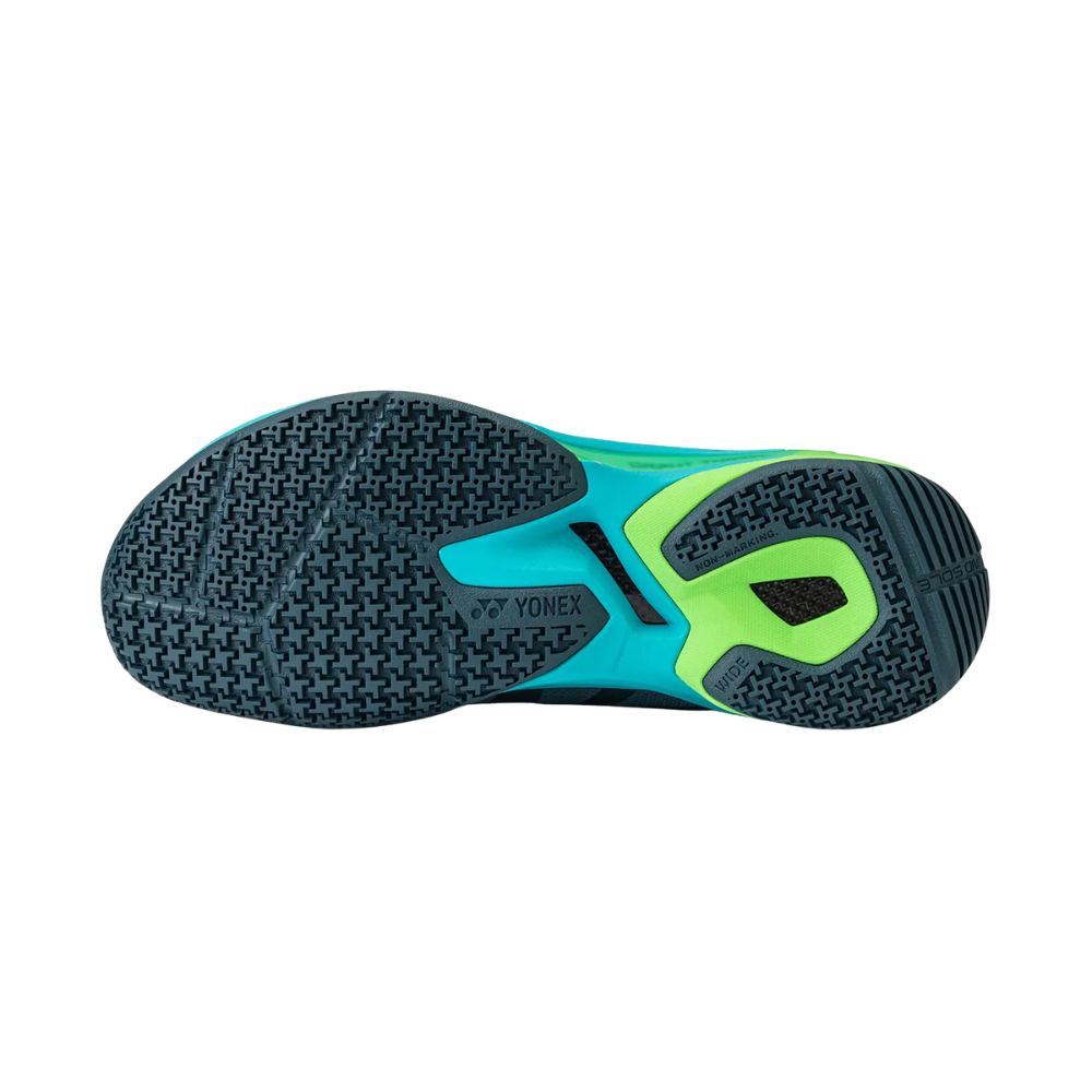 Yonex Subaxia GT badminton shoe outsole in teal and black with a bright green midfoot support accent and patterned grip