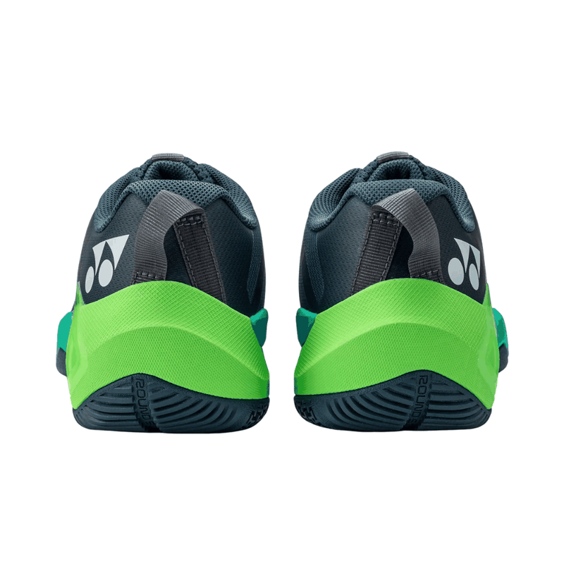 Yonex Subaxia GT badminton shoes feature dark navy mesh uppers, vivid green heel panels and textured rubber soles.