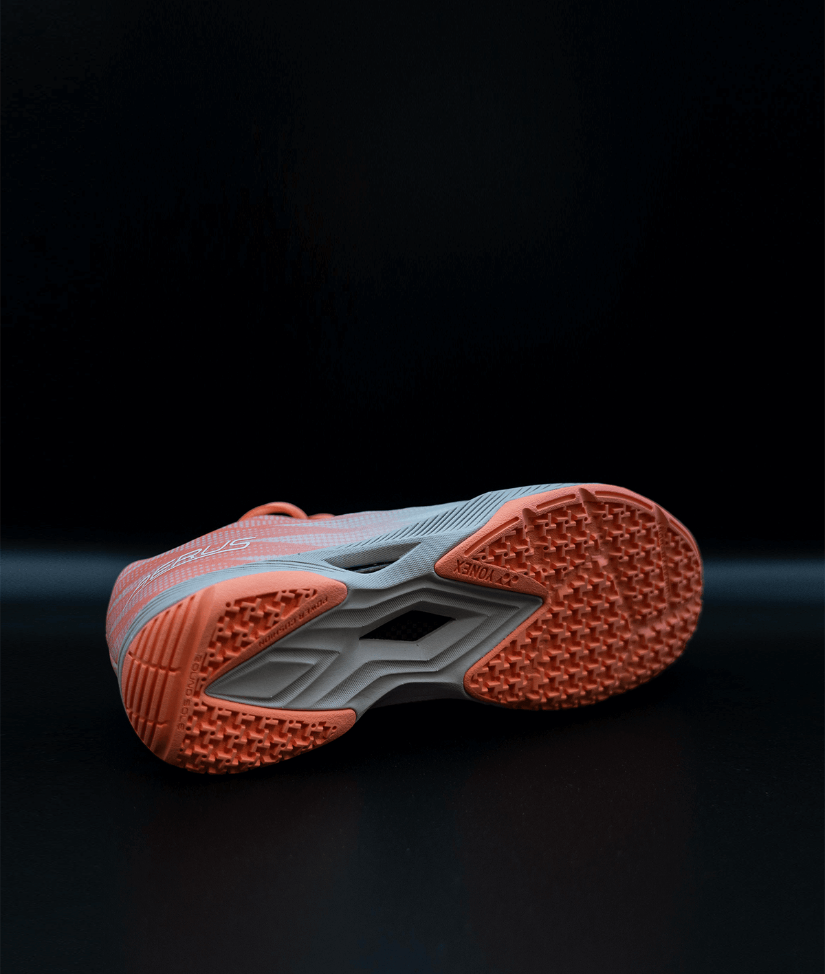 Yonex Aerus Z2 LX women's badminton shoe with a coral orange rubber outsole, textured tread and gray midfoot shank